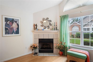 Living room featuring wood finished floors, a fireplace, and baseboards