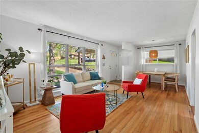 Livingroom with large picture window & hardwood floors.