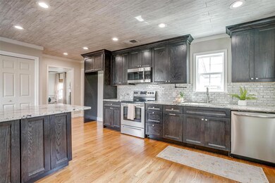 Kitchen with crown molding, a sink, tasteful backs