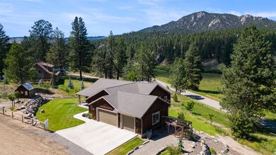 View from above of property with mountains and a heavily wooded area