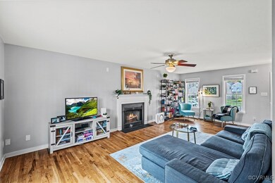 Living area featuring baseboards, ceiling fan, a f