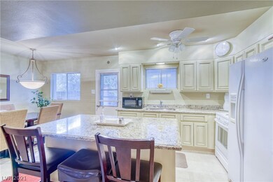 Island kitchen featuring granite counters, custom