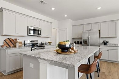 Kitchen with a center island with sink, light wood