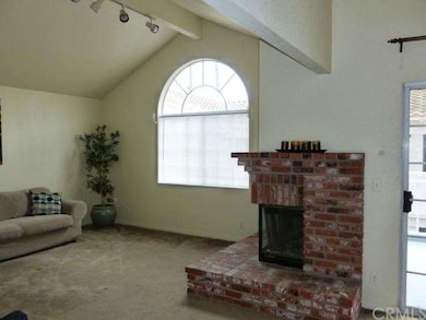 Living room with brick fireplace, high ceiling and