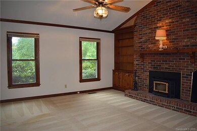 Living room with woodstove with fan.  To the right