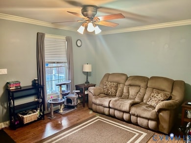 Living room featuring crown molding, hardwood / wood-style floors, and a ceiling fan