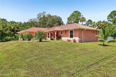 Back of property with a yard, stucco siding, and a metal roof