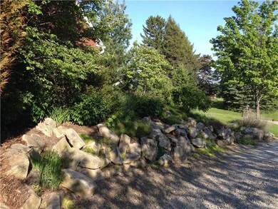 Land. Abutting the driveway is this hand lain wall