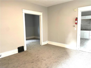 Living room with view to kitchen and one bedroom.