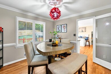 Dining room with crown molding, light wood floors, and baseboards