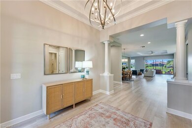 Hall featuring a notable chandelier, light hardwoo