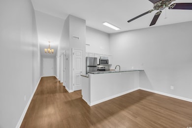 Kitchen featuring a peninsula, baseboards, applian
