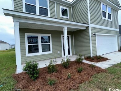 View of exterior entry featuring a garage and a po