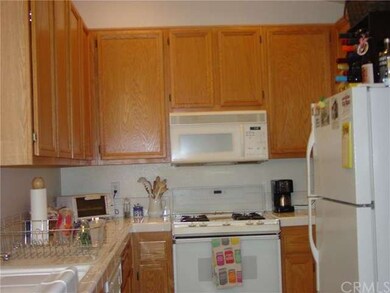 Kitchen features oak cabinetry, white appliances i
