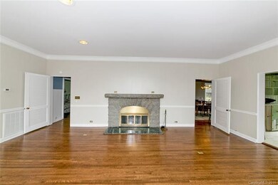 Large stone fireplace with refinished wood floors in living room