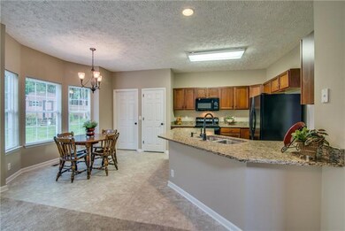 The light filled eat-in kitchen is open to the family room and allows for bar stool seating at the island.