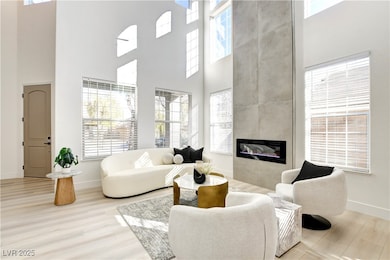 Living room with a towering ceiling, baseboards, w