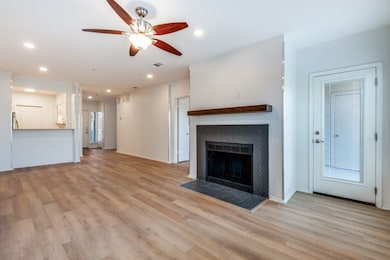 Unfurnished living room with ceiling fan, recessed lighting, light wood finished floors, and a fireplace with flush hearth