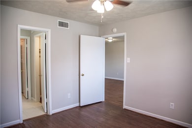 Unfurnished bedroom with wood finished floors, bas