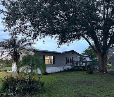 View of side of home featuring a wooden deck and a yard