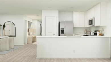 Kitchen with white cabinets, appliances with stain