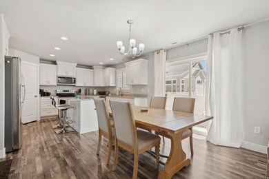 Dining area featuring a chandelier, dark wood finished floors, and recessed lighting