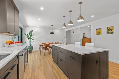 Spacious kitchen area with wood flooring and granite countertops