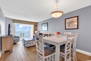 Dining area featuring wood finished floors, baseboards, and a textured ceiling