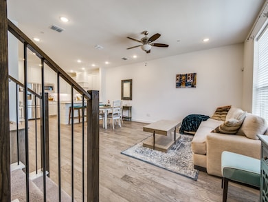 Living room featuring stairs, light wood-style floors, recessed lighting, and a ceiling fan