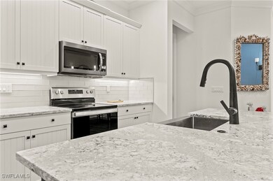 Kitchen with crown molding, backsplash, white cabi