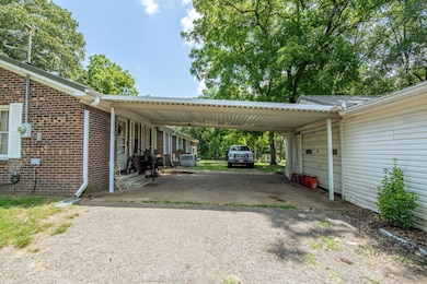 View of vehicle parking featuring driveway and an attached carport