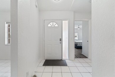 Foyer entrance featuring a textured wall and light