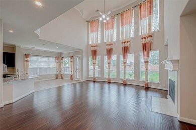 The living room features soaring high ceilings, co