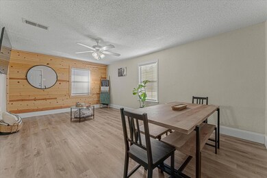 Dining space featuring ceiling fan, wooden walls, 