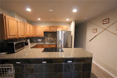 Open kitchen and bar area with granite counters an