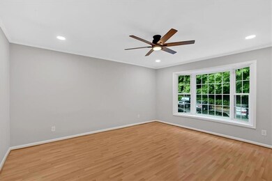 Spare room with a ceiling fan, light wood-style floors, baseboards, crown molding, and recessed lighting