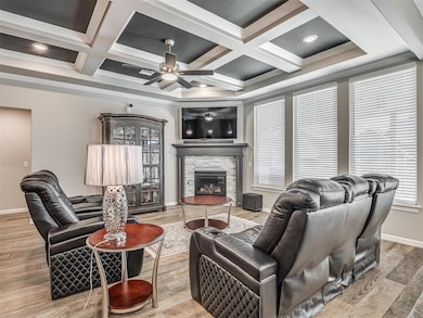 Living room featuring baseboards, a stone fireplac