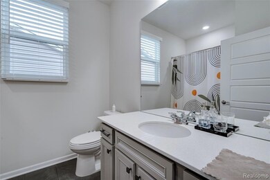 Full bathroom featuring vanity, curtained shower, and dark tile patterned floors