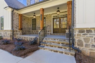 Property entrance with covered porch, french doors, and brick siding