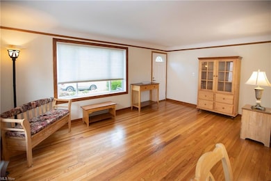 Sitting room with ornamental molding and light hardwood flooring