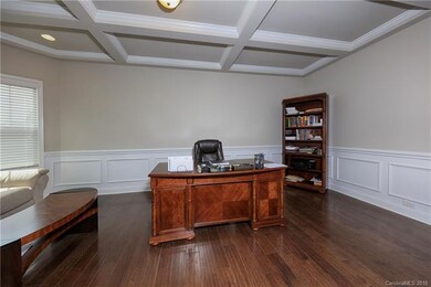 Coffered ceiling, hardwood floors, and wall detail