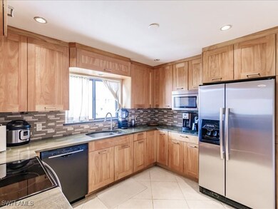 Kitchen featuring backsplash, appliances with stai