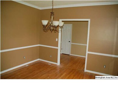 Formal dining room has hardwood flooring, crown mo