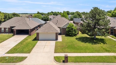 View of front of house with brick siding, a front yard, and driveway