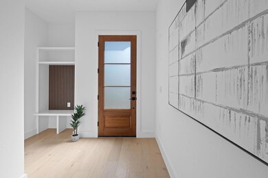Doorway with baseboards and wood finished floors