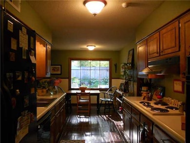 Wide galley kitchen with brick floor.