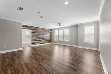 Unfurnished living room featuring an accent wall, 