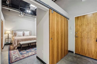Bedroom featuring concrete flooring and a closet