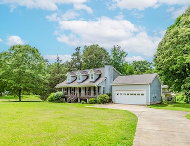Cape cod-style house with a porch, driveway, a fro