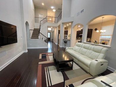 Living room with arched walkways, hardwood / wood
